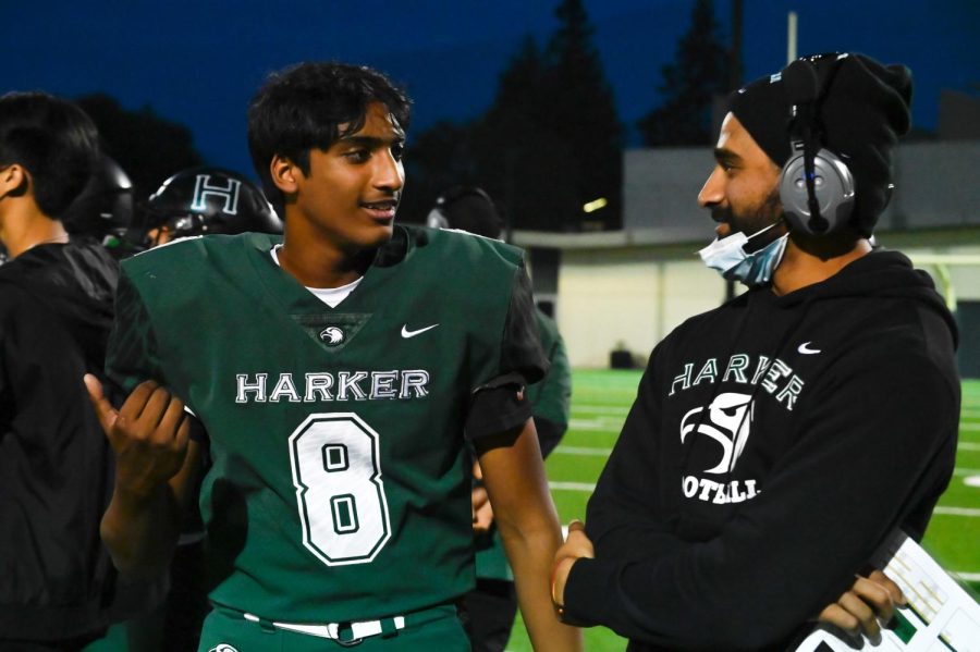 Quarterback Rohan Gorti (11) speaks with Coach Sidhart Krishnamurthi on the sideline during the varsity football team’s match against Crystal Springs last year. “Sid brings passion, organization, and energy to the program,” upper school athletics director Dan Molin said. “The students are picking up their respect for his passion and the seriousness of the sport, and hes bringing good positive energy.”