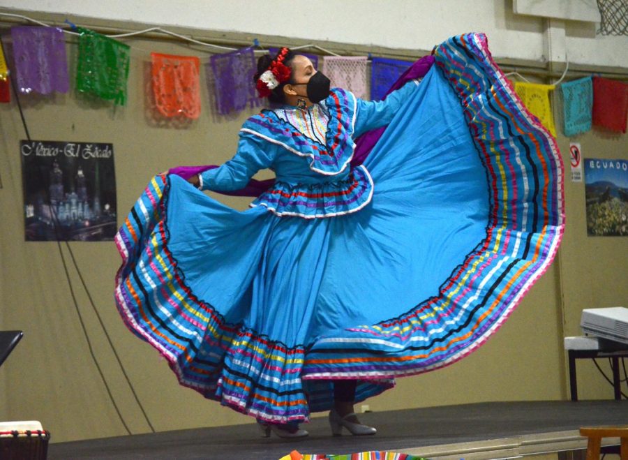 Upper school mathematics teacher Jeanette Fernandez sways her blue skirt to a Mexican folk dance, “Las Abajeñas.” Fernandez performs this dance every year at Spanish Cultural Night, which made a return in-person this year on March 11.