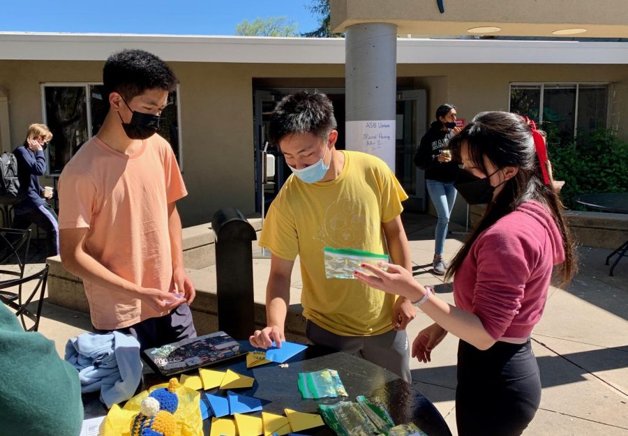 Brian Chen (11), Kevin Wang (12) and Alice Feng (12) stand by Research Club and Medical Club's fundraiser during lunch on Tuesday. Various organizations held fundraisers to raise money for the UN Refugee Agency.