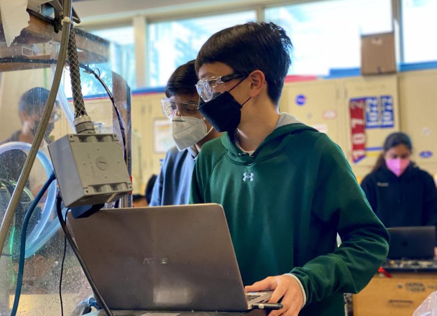 Brendon Hayes (9) and Akul Goyal (9), members of Harker Robotics mechanical and machining team, wear masks inside Nichols as they run the router during Robotics weekend work session today. As of April 18, Harker will no longer require middle and upper school community members to wear masks indoors. 