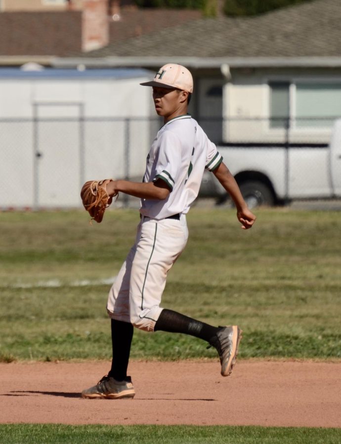 Infielder Aaron Lo (12) slows to a jog after he throws a ball hit into left field to a teammate in order to catch out a Half Moon Bay batter. The Eagles ultimately were not able to retire the batter, who scored a run.