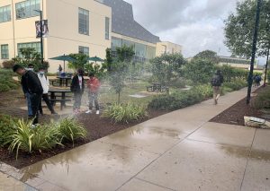 Students look on as the sprinkler sprays others exiting the library. “I was very surprised, of course, you don’t really see that kind of thing every day,” said Richie Amarillas (12), who was outside the library when the pipe burst. “When I looked outside I just thought it was raining because it was supposed to rain today, but no, it was a sprinkler.