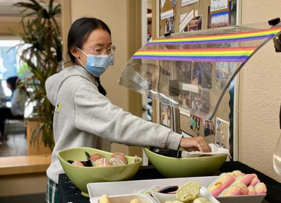 Lexi Wong (11) reaches for a colorful dessert in Manzanita Hall on Wednesday. “I really like the checkerboard cookies that my intern did,” pastry chef Adam Albers said. “They are layers of multicolored dough that are cut up into squares and then re-put together and then formed into a cookie, so you get a really distinct little pattern.”