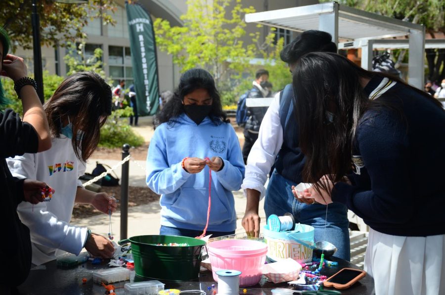 Students make bracelets outside of Manzanita Hall on Wednesday. The days activities also included posting handwritten messages on the “Be U” board and dressing up to celebrate Wednesdays spirit theme of LGBTQ+ pride.