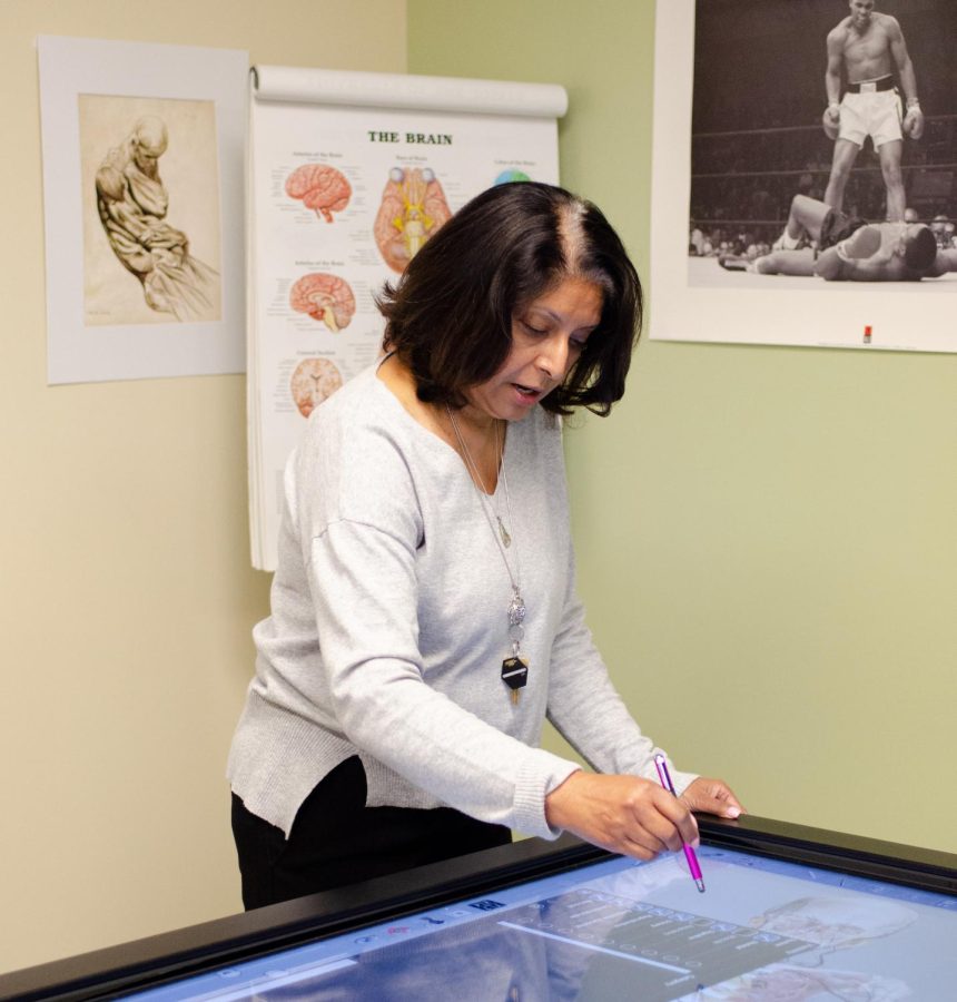 Using a stylus, upper school science department chair and biology teacher Anita Chetty selects certain features on the body to be visible. The table also allows the user to place labels on body organisms, view the flow of blood in the veins, and take a quiz on the anatomy of the cadaver.