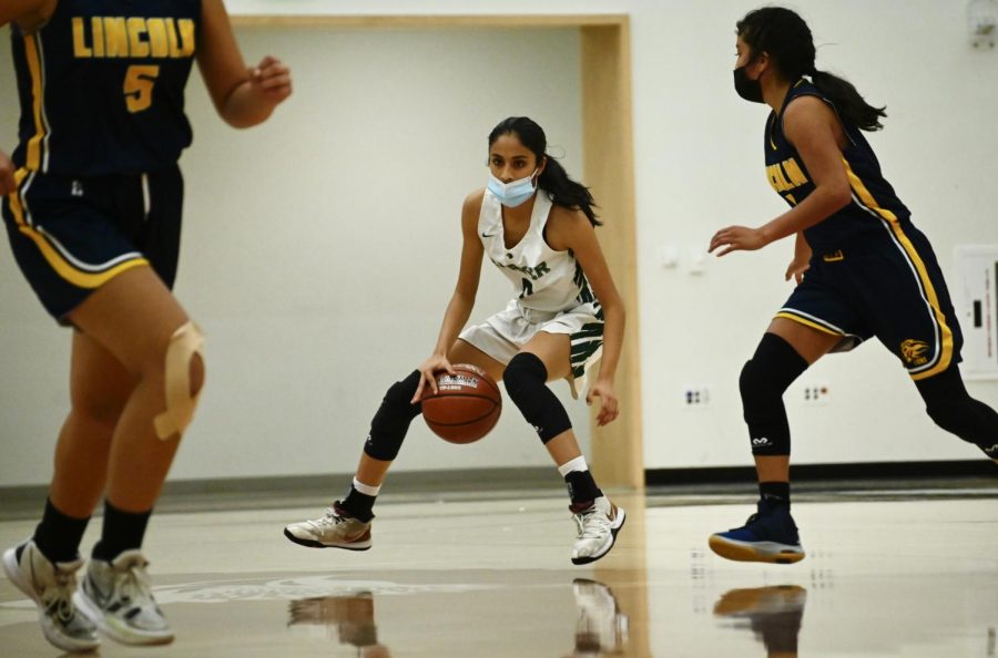 Anjali Yella (11) dribbles the ball in a varsity girls basketball game against Lincoln High School. The varsity girls basketball team led a strong season last year, making it to the CCS championship final and placing second in the CCS fourth division in February.