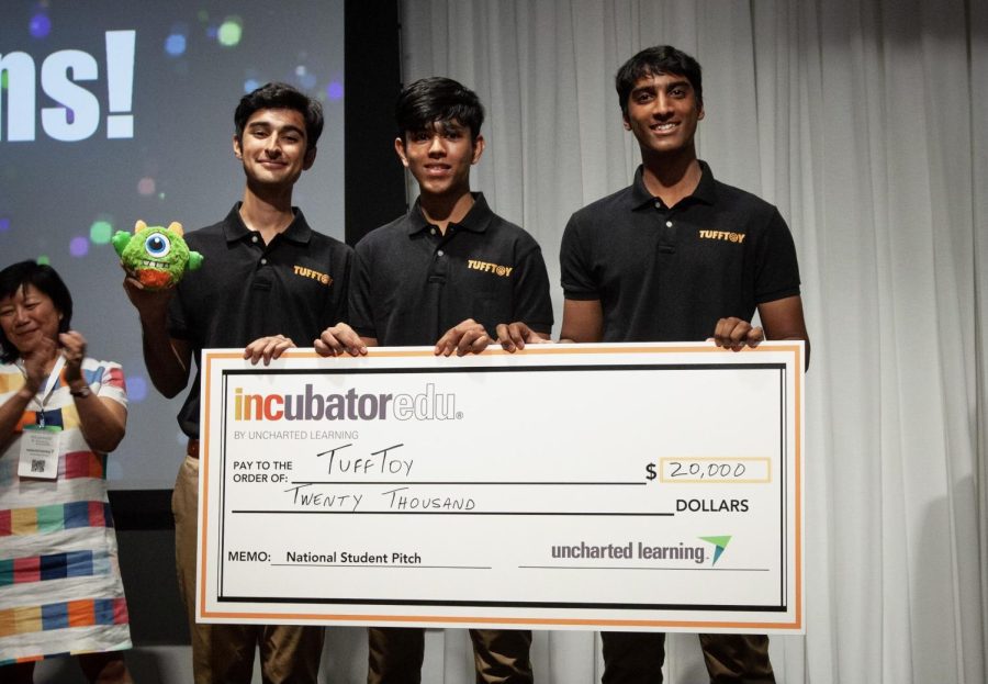 Seniors Zubin Khera, Arin Jain and Rohan Gorti hold up a check of $20,000 written to TuffToy after winning the National Pitch Competition in Chicago in July. The three founded TuffToy in their junior year to sell customizable and durable dog toys.