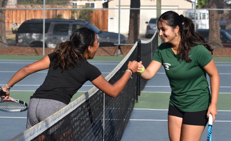 Anushka Mehrotra (12) and Medini Halepete (11) fist bump each other after finishing practice sets during tennis practice. Following the girls tennis teams Northern California Section I championships last year, the team faces lofty expectations for the coming season.