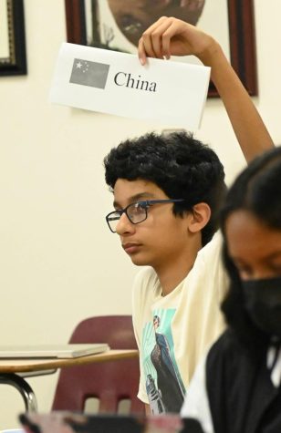Rahul Sundaresan (9) raises a card with the name China during the Model U.N. kickoff yesterday. The kickoff, with over 30 student attendees, included a mock conference about several topics.