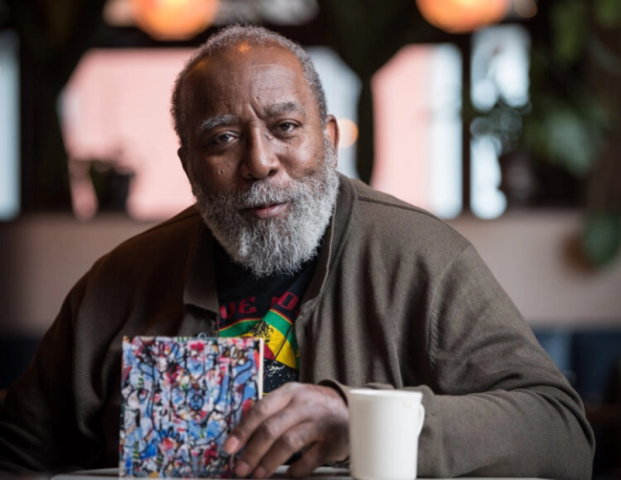 Visual Artist Ta-coumba Aiken poses with one of his works. Aiken was awarded a 2022 Guggenheim Fellowship Award recognizing him for his work in dynamic art, specifically spirit writing and rhythm patterns. 