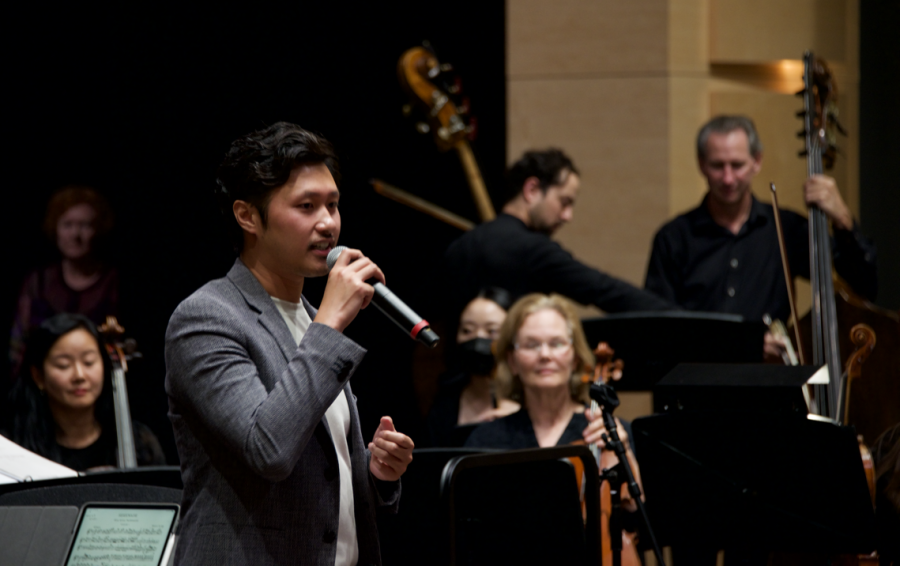 Instrumental music teacher and artistic director of the Harker Concert Series Jaco Wong speaks at Fridays performance. Jaco introduced his own piece the “Whampoa Overture, which was then performed by the orchestra.