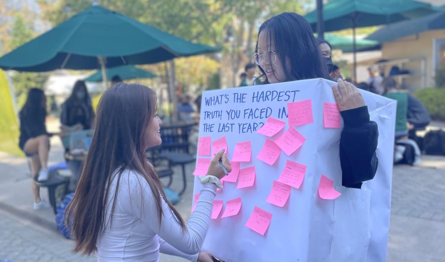 Eileen Ma (12) writes on Honor Council representative Gwen Yang’s (12) box on Sept. 27. The council organized activities and goals for each day last week to remind students of the four tenets of the upper school.