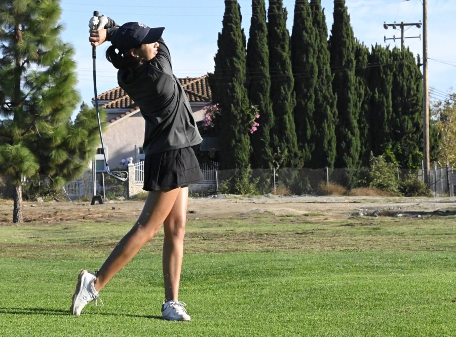 Kimaya Mehta (9), playing for her first year on the high school varsity girls golf team, follows through with her swing. The girls golf team emerged undefeated in the West Bay Athletic League (WBAL) for the fifth consecutive year, making it to the Central Coast Championships (CCS). 
