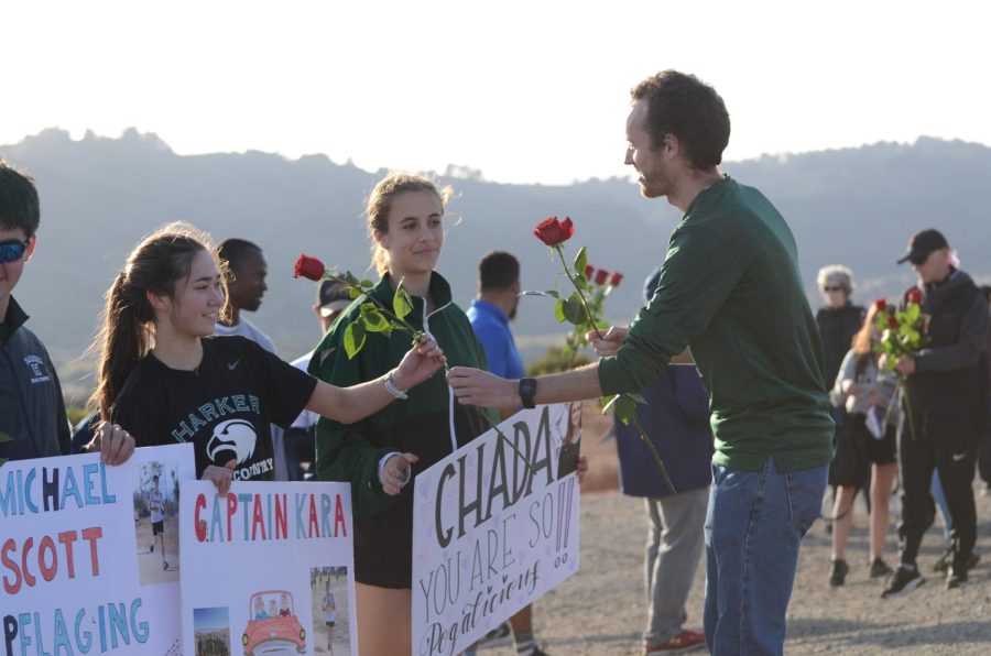 Cross country head coach Kevin Oliver hands flowers to seniors Kara Kister and Ada Praun-Petrovic. “It’s really sad [to be leaving]; I cried a bunch today,” Kara said. “Since I’ve been on the team for so long, and I see them every single day and all these people, it’s really sad to be leaving.”