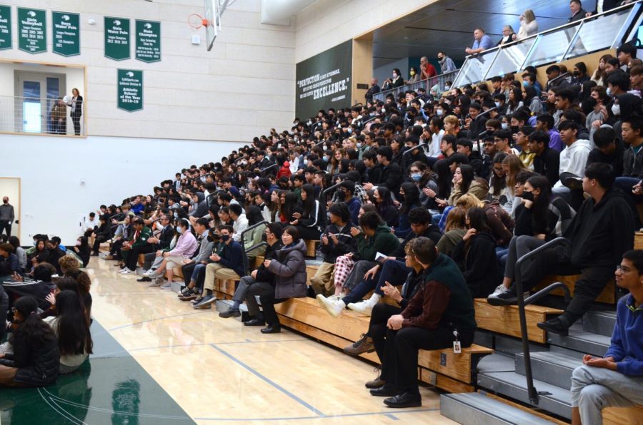 Students sit in the Zhang Athletic Center during Tuesdays school meeting. During the school meeting, students and faculty watched water polo and tennis senior athletes test their knowledge on each others sports.