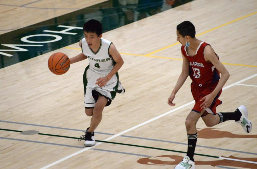 Ethan Lei (9) dribbles the ball down the court. The Eagles jumped to an early lead and grew it through a barrage of two-pointers and free throws.