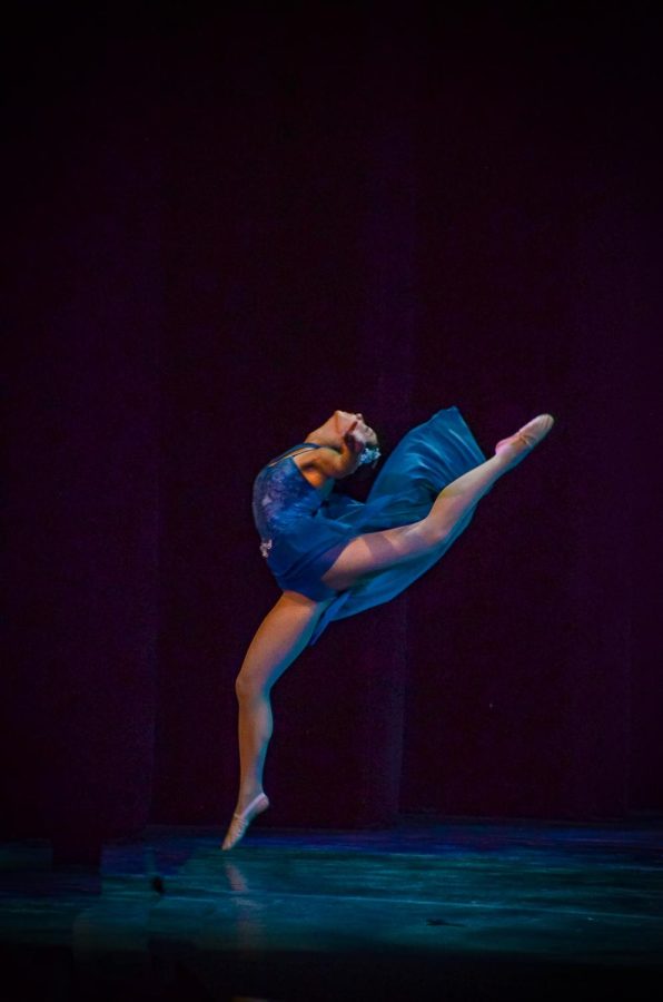Emma Cai (11) leaps in "Young and Beautiful." The lyrical routine featured flowy costumes and melancholy blue lighting, the work of student choreographer Anja Ree (12) and  lighting designer Natalie Pierce Thompson.