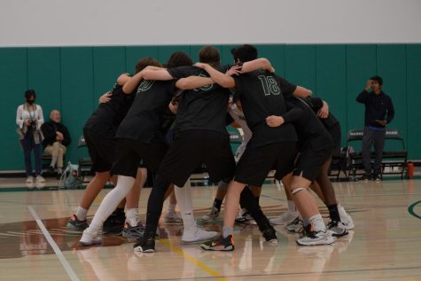 The varsity boys volleyball team gathers for a huddle and a chant before the game against Menlo-Atherton on Tuesday. The team won in three sets, 25-13, 25-14, 25-20.