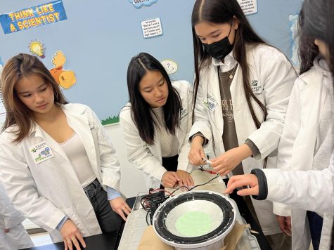 WiSTEM Co-President Eileen Ma (12) and STEM Buddies Directors Michelle Wei (11) and Margaret Cartee (11) prepare an oobleck demonstration to teach lower school students about non-Newtonian fluids. The recent STEM Buddies event featured five stations where participants could learn new concepts through hands-on activities and discussions.