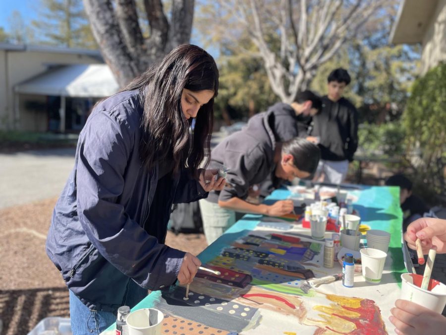 The class of 2026 works on their banner in front of Manzanita Hall after school Friday. Each class received a different city on which to theme their banner, with the frosh painting Chicago.