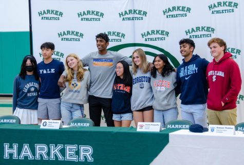 Committed senior athletes pose for a picture at signing day, wearing their respective college apparel. They took photos with family, friends and audience members after the ceremony.