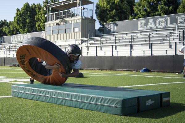 Safety Daniel Lin (12) hits a wheel during a tackling drill. Daniel has played for the Harker football program since his freshman year, and he is a co-captain of the team this year.