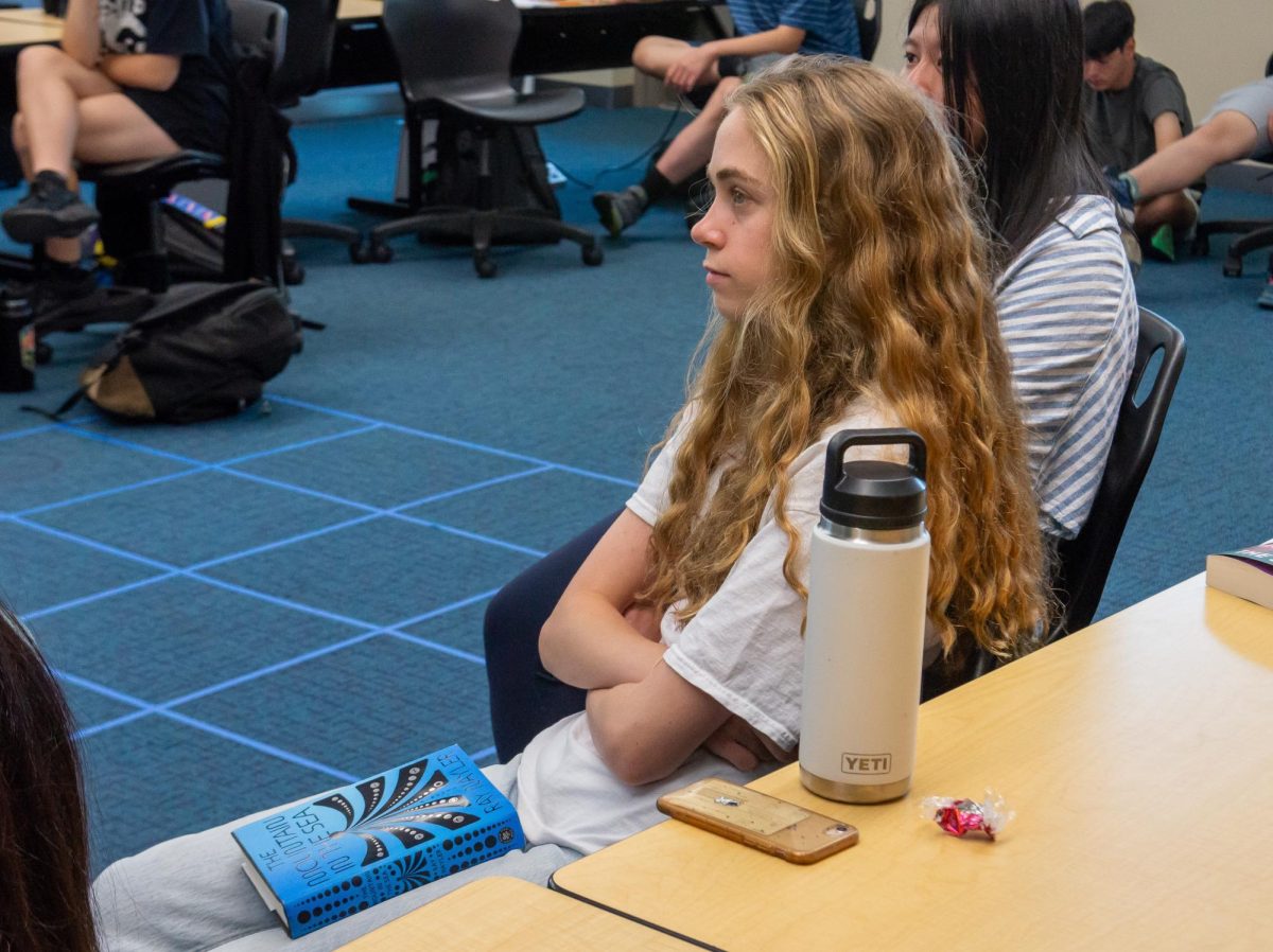 Avery Jones (11) sits with Ray Nayler's "The Mountain in the Sea" on her lap as she listens to Nayler speak to the ReCreate Reading group. Nayler was a featured visiting author this year alongside Parini Shroff.