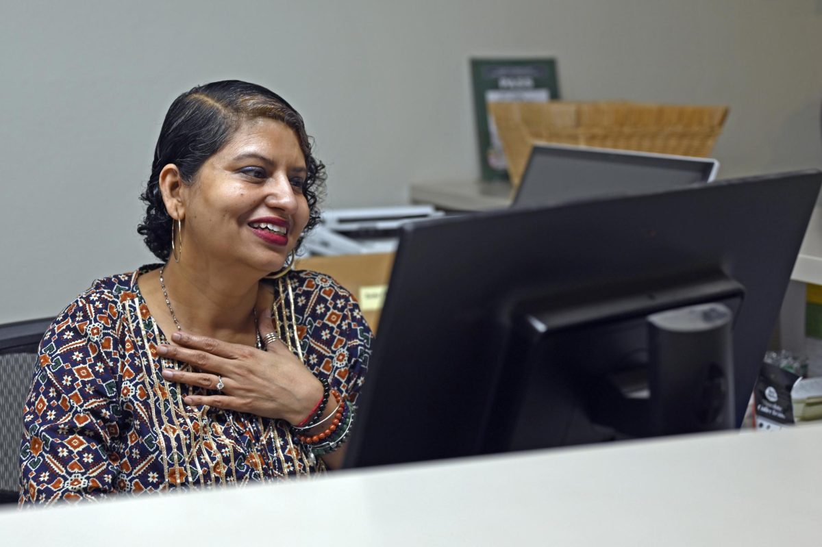 Attendance Coordinator Ritu Raj smiles as she reads an email at the front desk in Main Hall. In addition to tracking the attendance of over 800 students at the upper school, Raj promotes wellbeing and supports those around her through resilience coaching.