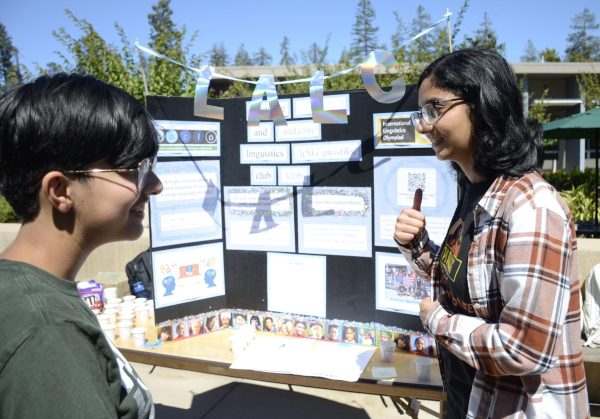Ritu Belani (12) discusses the Language and Linguistics Club with Anoushka Chakravarty (10) outside the Athletic Center (AC) during Club Fair on Tuesday. The Language and Linguistics Club hosts activities like the North American Computational Linguistics Open (NACLO) competition and language puzzles.