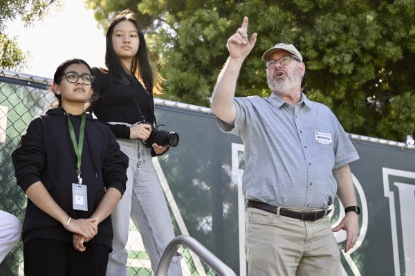 Executive Director of the Association of Texas Photography Instructors and Harker Journalist-in-Residence Mark Murray points out sports photography basics to journalism students Sid Sanghari (11) and Michelle Wei (12) on Sept. 27. Students practiced taking photos at different locations on campus including Nichols and Davis Field.