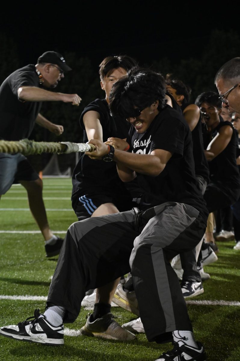 Reza Jalil (12) pulls on the rope during tug of war. The seniors fell to the juniors, emerging as second place in the competition overall.
