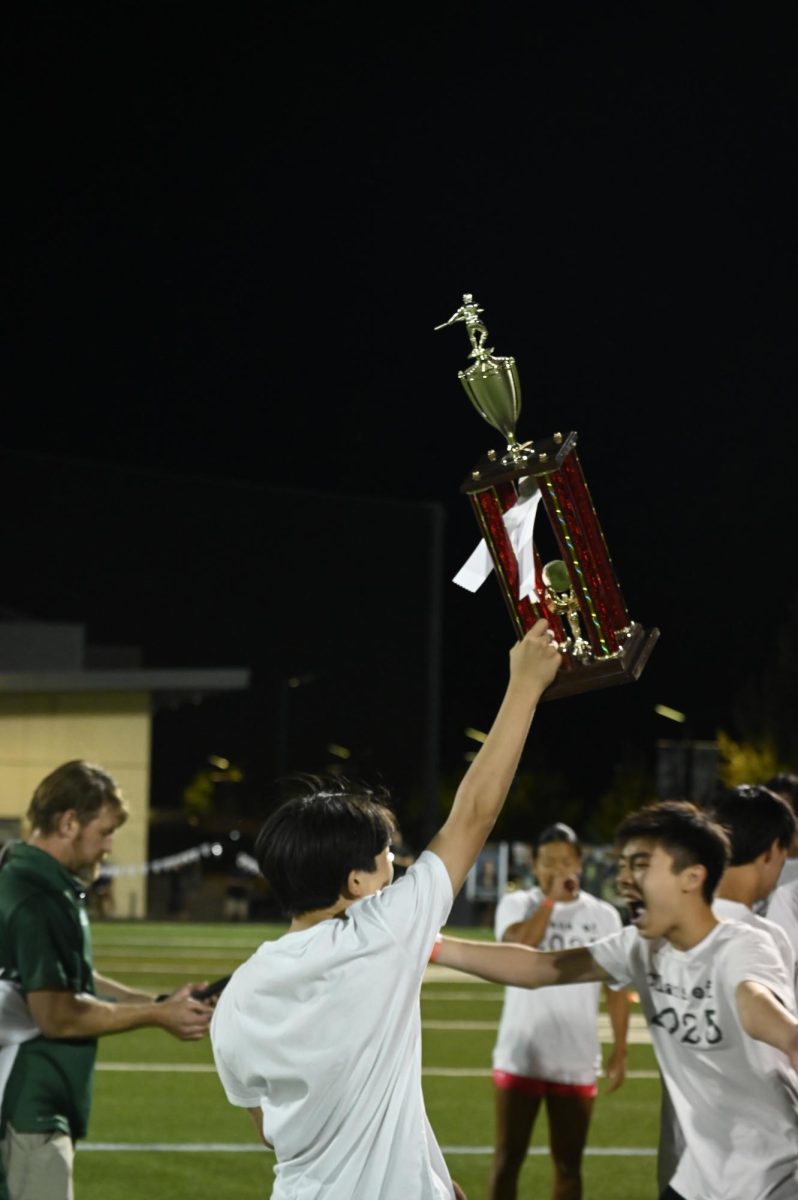 A member of the junior class holds the tug of war trophy. The juniors won against the seniors, leaving them in first place for the second year in a row.