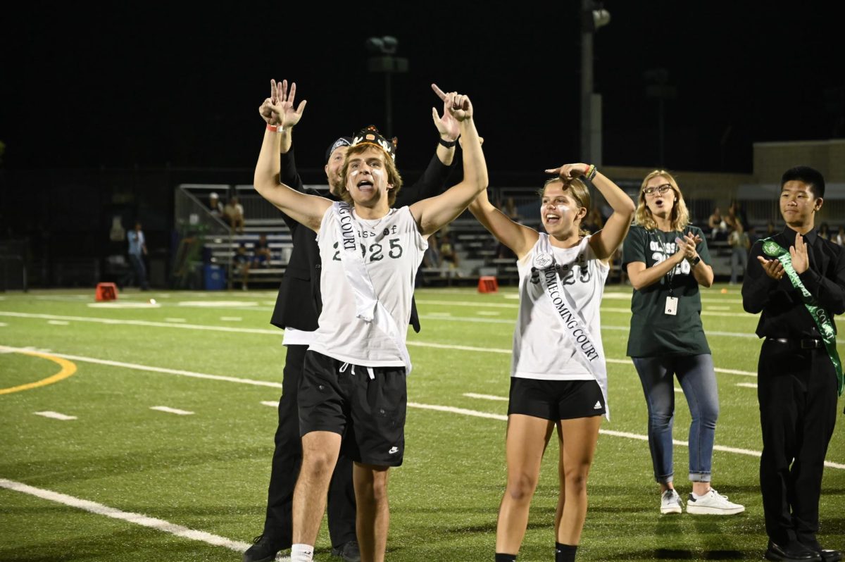 Junior Homecoming Court Picks Leo Sobzycn (11) and Claire Anderson (11) cheer during the Homecoming Royalty Presentation. Members are elected by their class each year. 