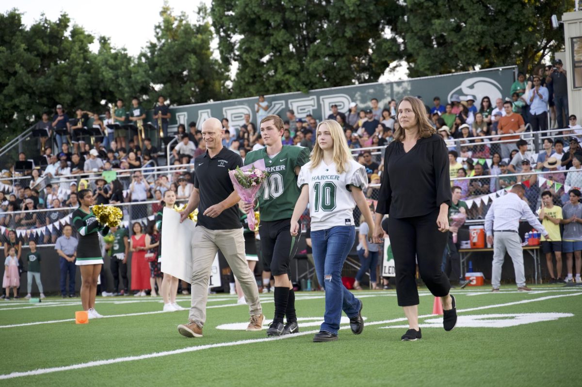 Senior football team member Ryan Barth strides on to the field with his family members.  “I think senior night is important because they each put a lot of time into the sport that they love,” Om Tandon (12) said. “There are a lot of things that we as fans can’t see.”