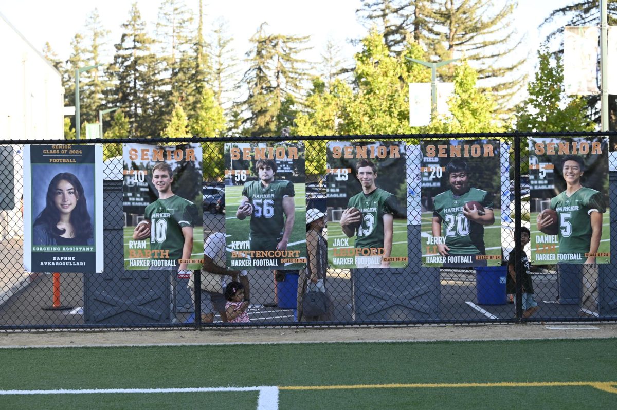 Senior photos hang on the fence field. Senior night will be held during half-time to celebrate the five departing seniors of the Harker Football team. 