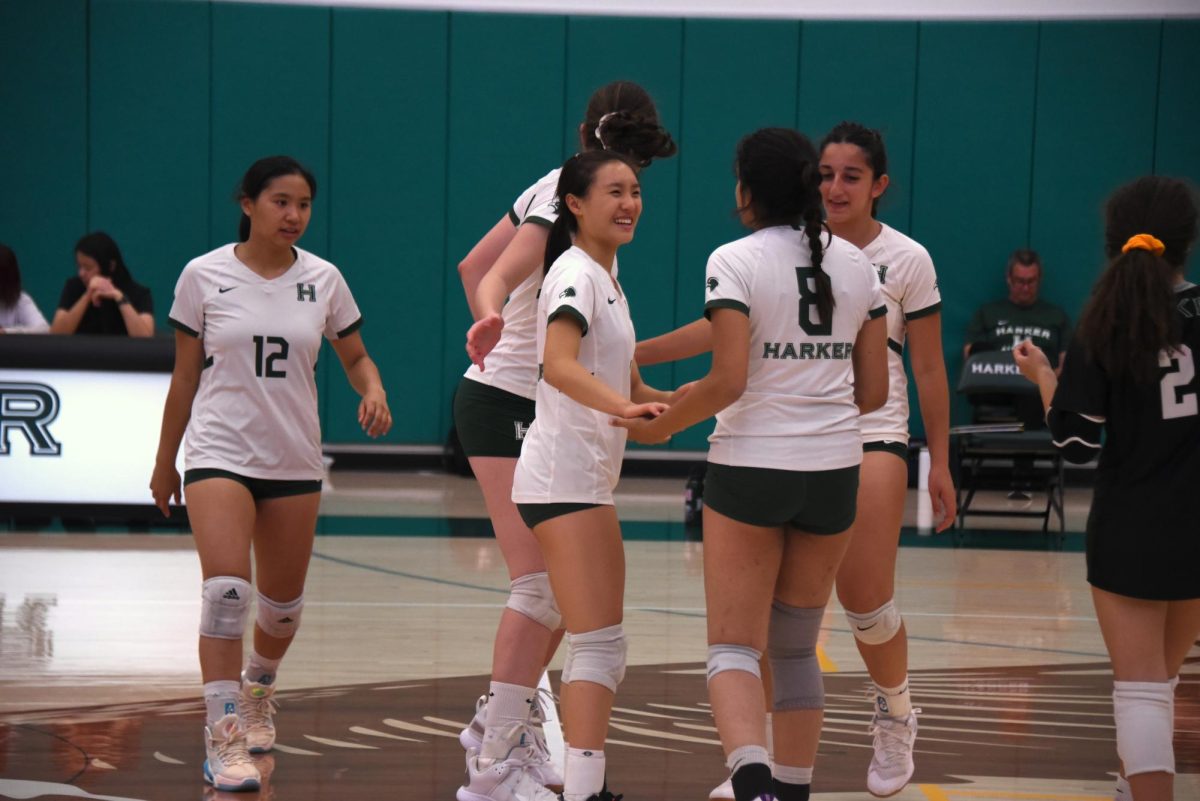 Setter Keira Chang (10) huddles with teammates after scoring an ace serve. Keira played her second year on varsity this season. 