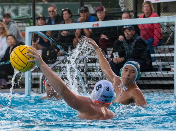Adam Pawliger (11) concentrates on tracing the opponents ball with his arm to block a shot attempt. Many players from both teams knew each other through club water polo, fueling the rivalry between their school teams.