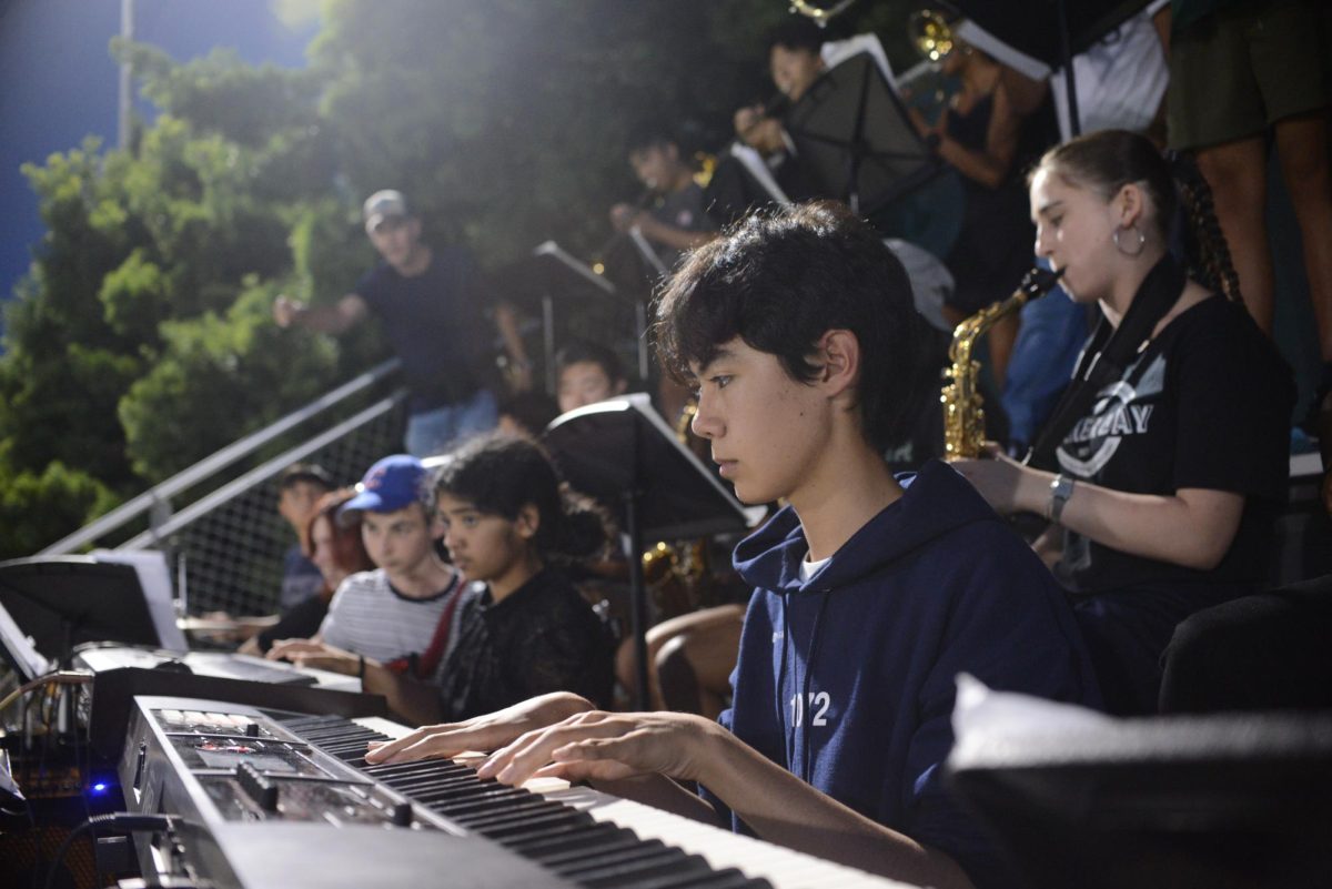 Arturo Villalta (10) plays the keyboard during the game. Pep Band opened the game and continues to play throughout.