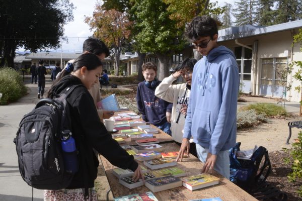 Book Blog member Kristiyan Kurtev (9) helps students choose books during the book swap at lunch in the Quad on Thursday. Last year, Book Blog also hosted a book drive, except it was in collaboration with the Green Team for Earth Week.