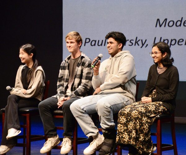 Om Tandon (12) smiles as he answers a question during the senior panel at the eighth grade introduction to the upper school. Om was one of the eight seniors selected to participate in the panel.