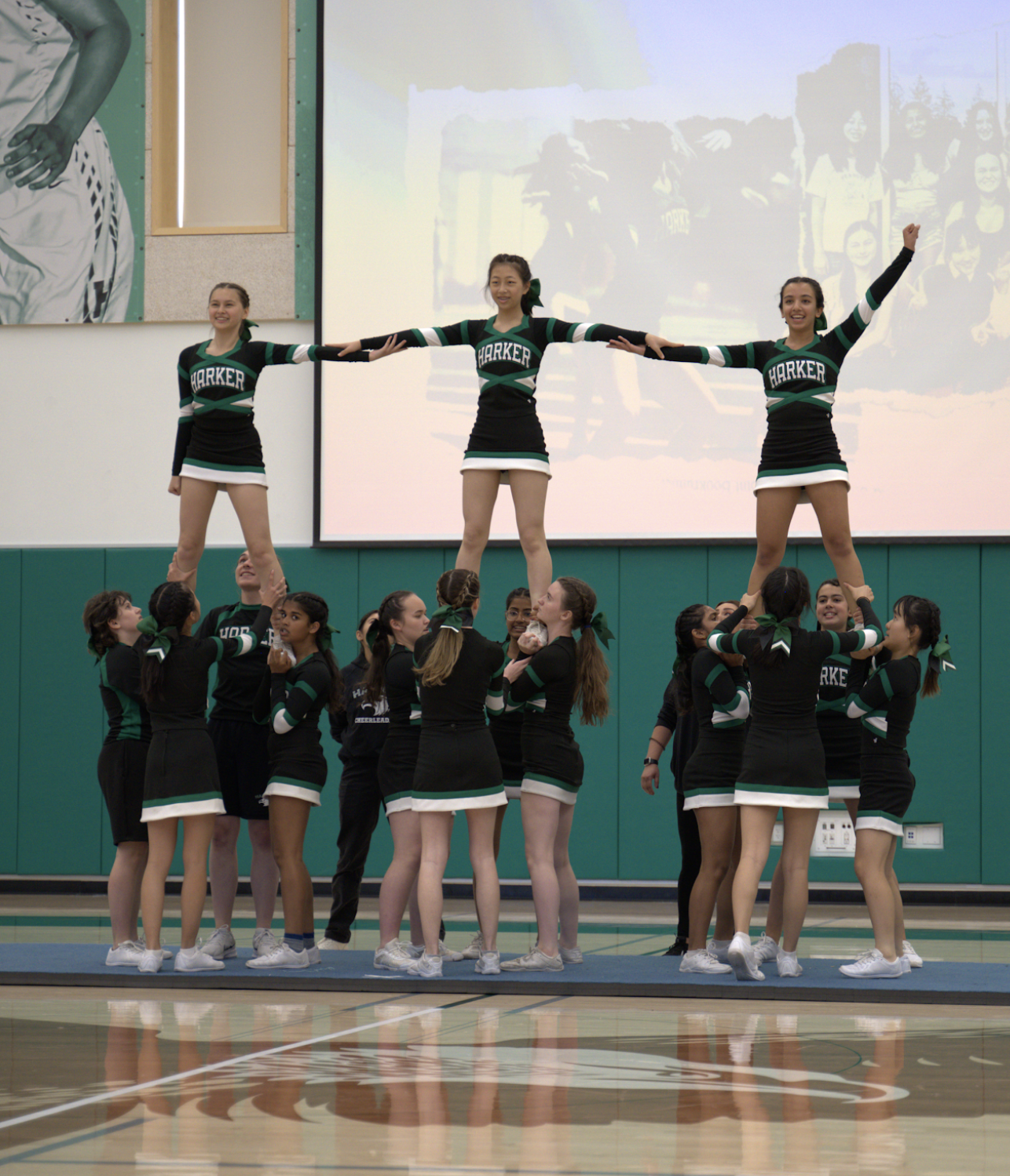 The cheer team lifts three members into the air during the spirit rally on Oct. 5. With a total of 15 members this year, the size of the team increased fivefold, and their hardworking spirit and close-knit relationships continue on. 
