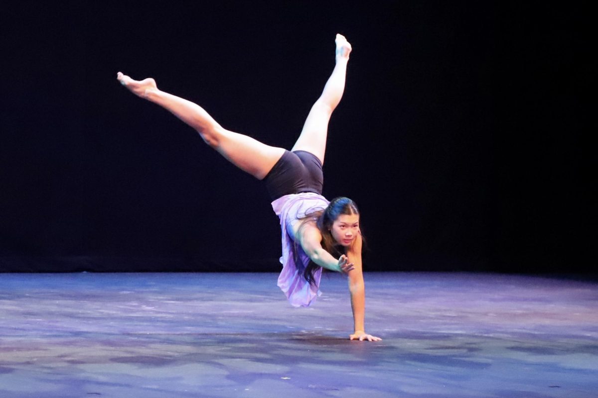 Sophomore Linda Zeng outstretches an arm while holding a handstand in her contemporary solo to “Talk to Me. Lindas dance was the second performance in the Hoscars.