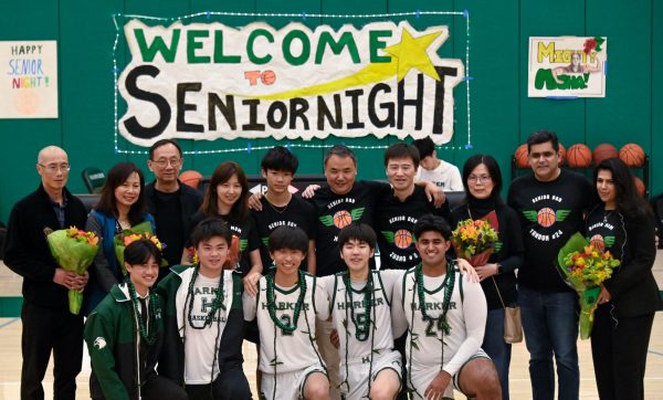 The varsity boys basketball team seniors line up for a photo with their parents. The team had an overall record of 6-18. 