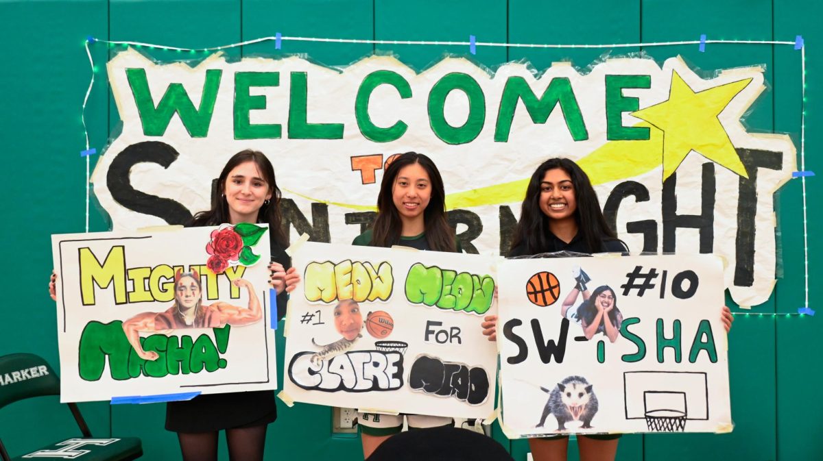 Seniors Masha Velikhovskaya, Claire Miao and Isha Kotalwar hold their posters for a photo. The seniors were gifted flowers and posters from their teammates and families. 