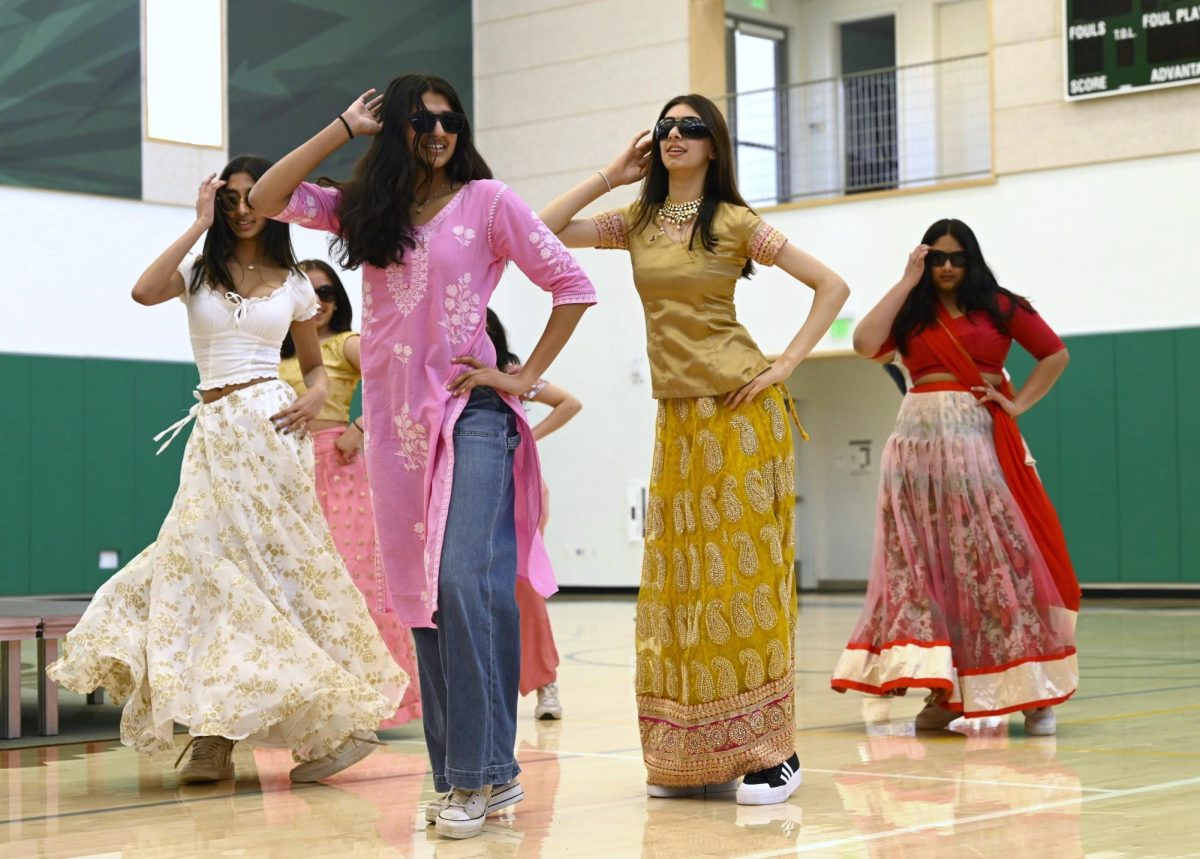 Riya Samuel (9) and Ivanya Sadana (9) dance to a Bollywood routine during Mondays assembly. The Student Diversity Coalition opened the showcase by introducing culture week and promoting events later in the week like a chalk art activity.