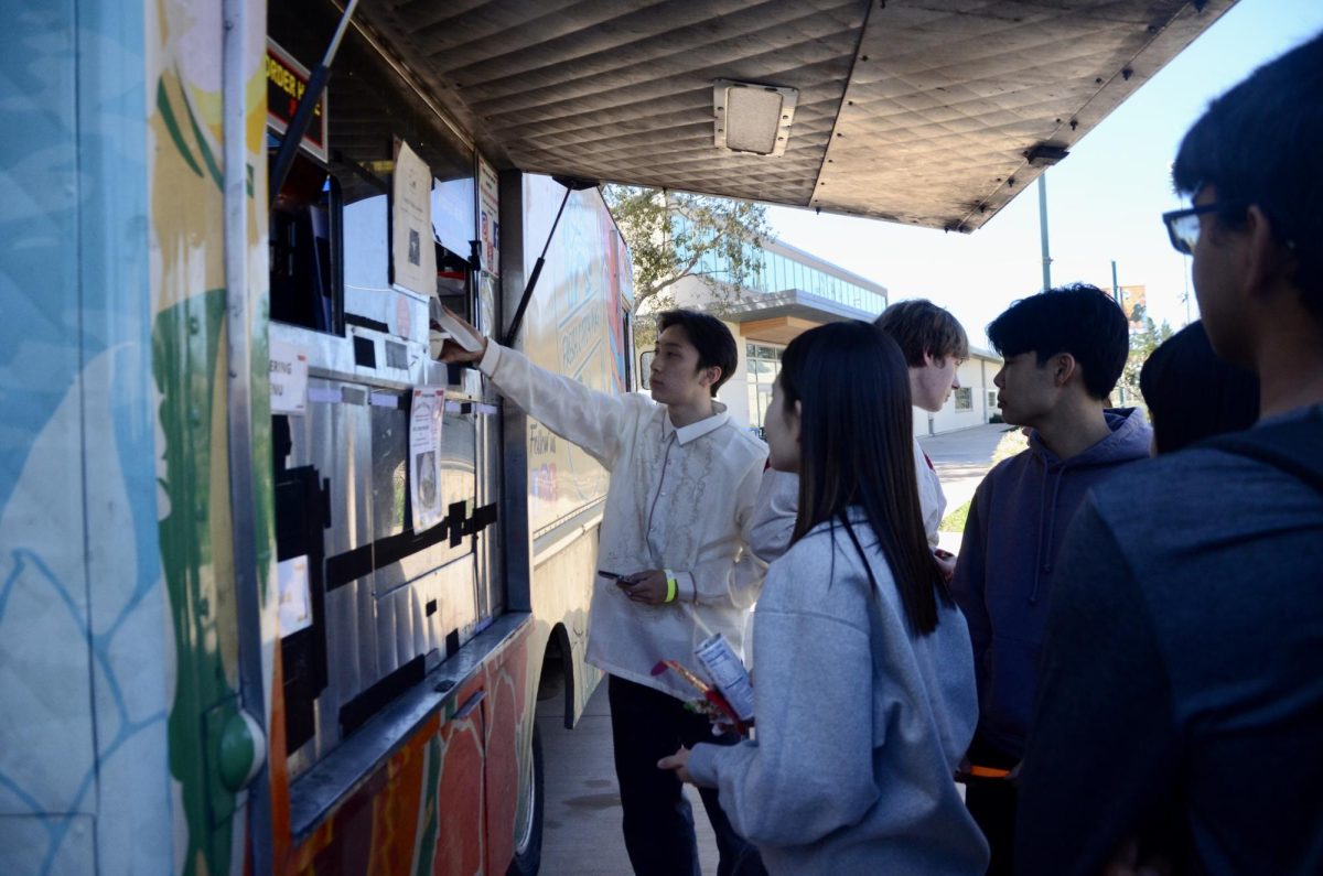 Spencer Mak (12) orders food at Fresh Catch Poke outside of the Rothschild Performing Arts Center. Fresh Catch Poke ran out of ingredients at 12:40 p.m. and made 57 more orders than initially planned.