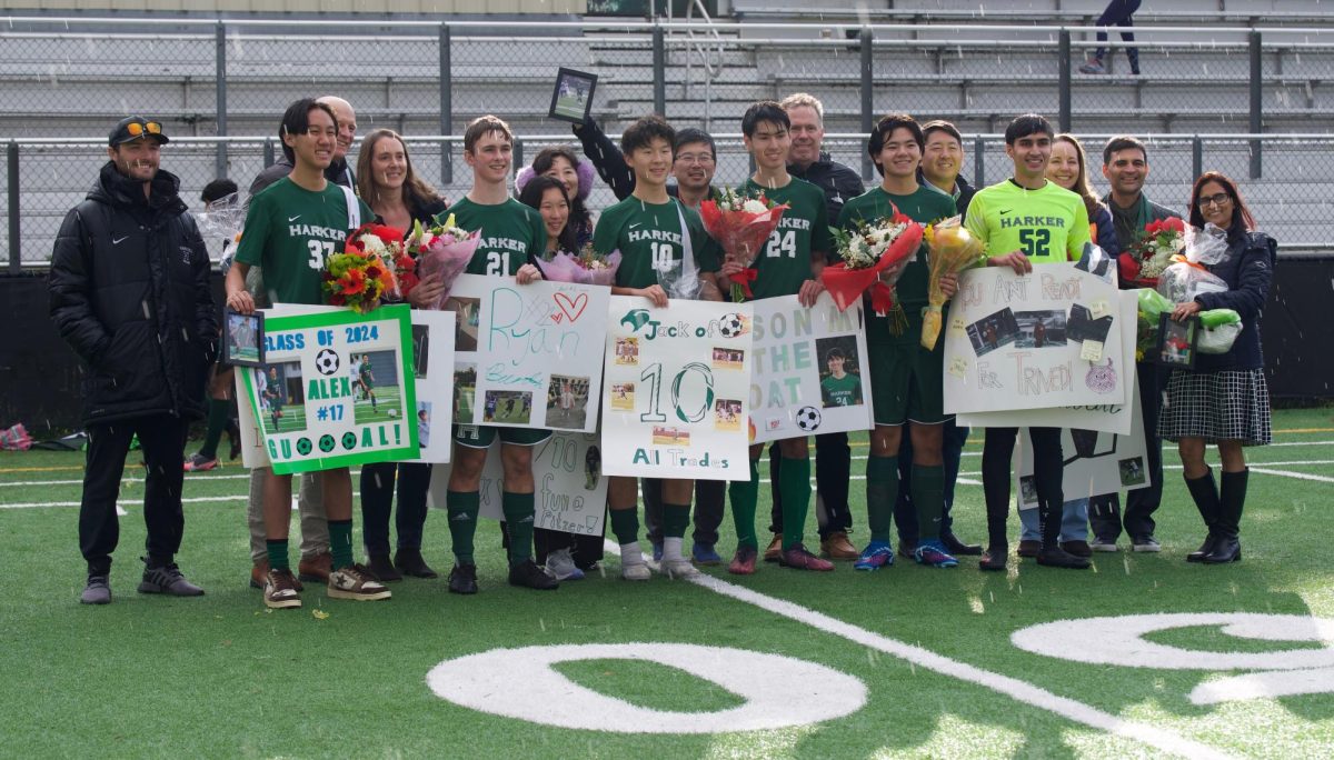 Varsity boys soccer seniors stand with their families and head coach Ryan Masch for a photo. The team overcame SHP 5-0.