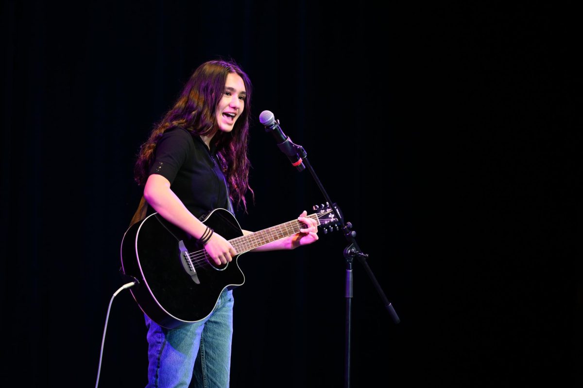 MacEnzie Blue (10) sings a cover of Drops of Jupiter while playing the electric guitar. She performed in one of six other Hoscars singing acts.