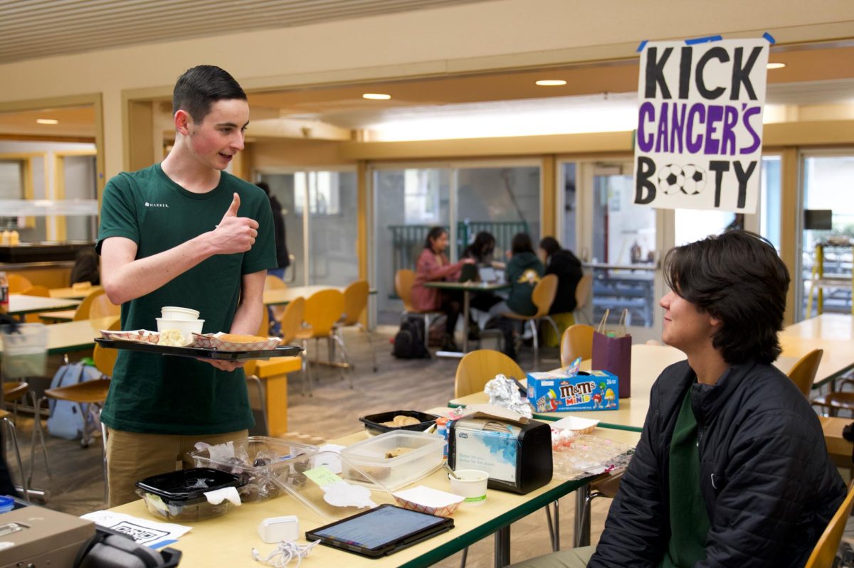 Junior Harriss Miller gives a thumbs up to senior varsity boys soccer team member Ben Cha during the Kicks Against Cancer bake sale on Feb. 31 in Manzanita Hall. Fundraiser proceeds go to Camp Okizu, a nonprofit organization that organizes camp sessions for children with cancer and their families in Northern California.