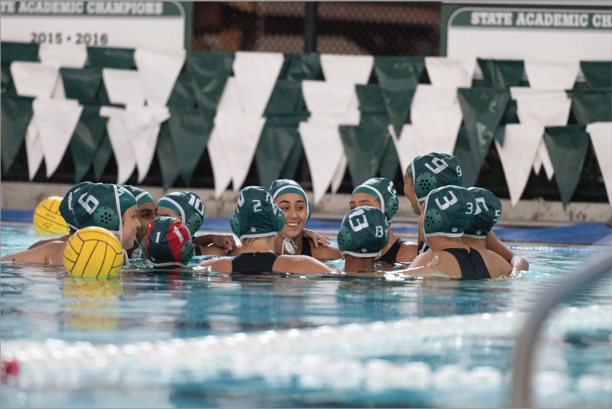 The varsity girls water polo team huddles during a timeout in their game against Palo Alto. The Eagles eventually lost the match 5-10. 
